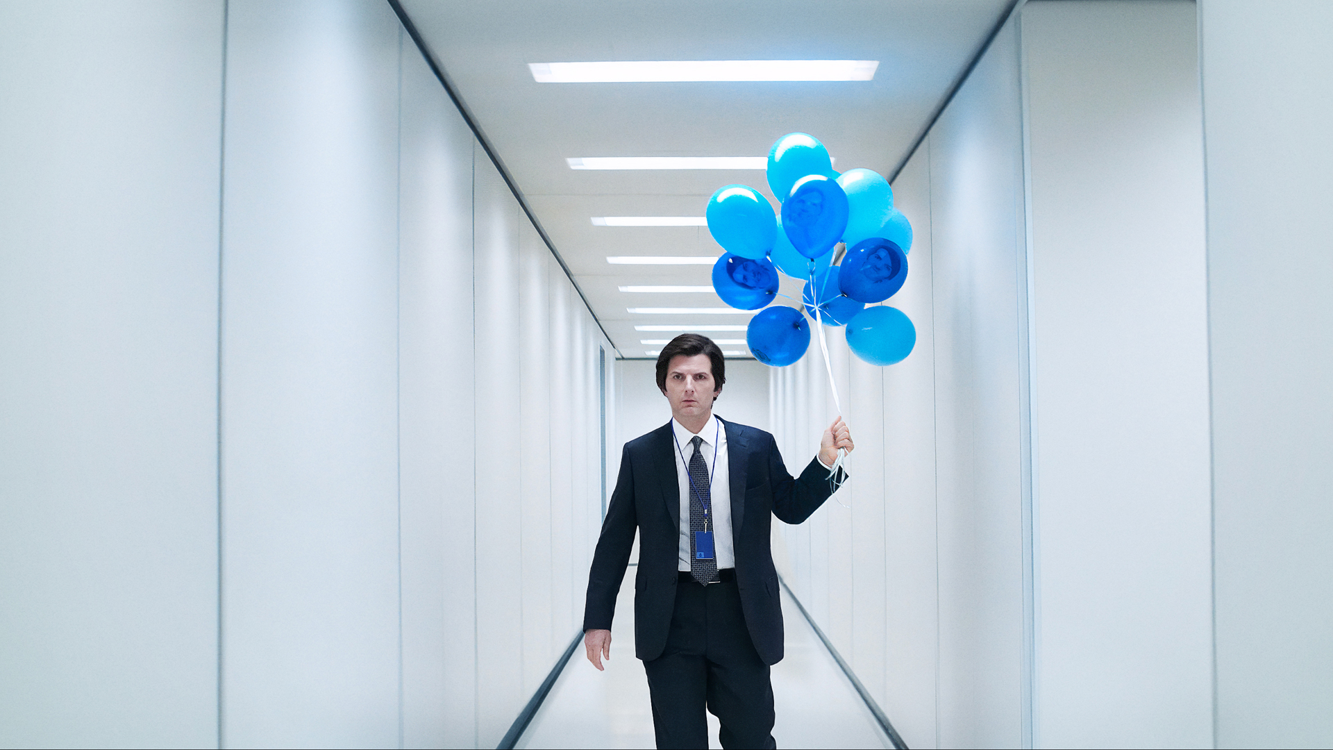 Adam Scott in Severance season 2 holding blue balloons down an ominous hallway